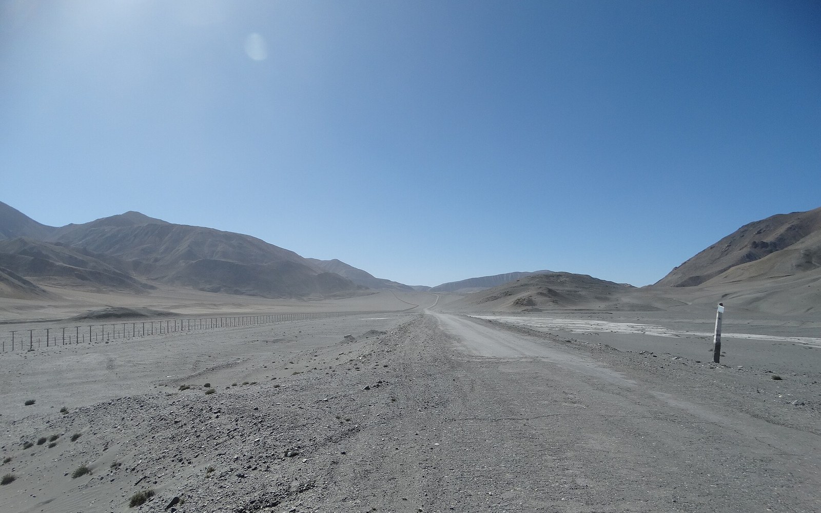 a mountain road switchbacking into haze